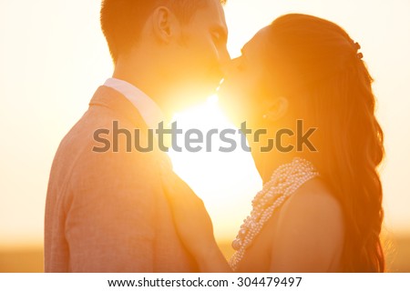 Wedding couple kissing in a field of rye