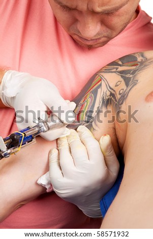 stock photo : Portrait of professional tattoo artist inking and drawing on 