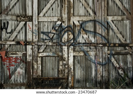 Graffiti on a tin and wood fence / gate.