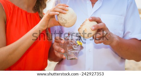 hands in the shape of a heart on the background of the sea  Male and female hands with rings holding sand and shells coral with a wedding ring on the beach