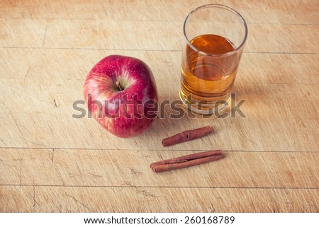 apple and a glass of apple juice on a wooden board