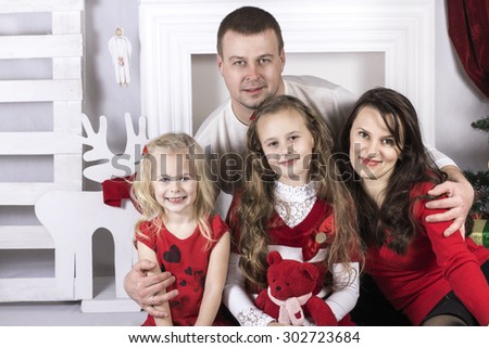 a family man, a woman and two girls in Christmas cover and interior