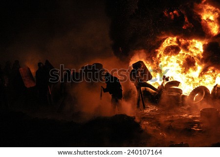 People on the fire take part in a clash at the Grushevskogo street during anti-government protest in Kiev, Ukraine, January 25, 2014