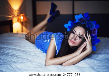 beautiful young fashion model brunette with high heels lying in the bed