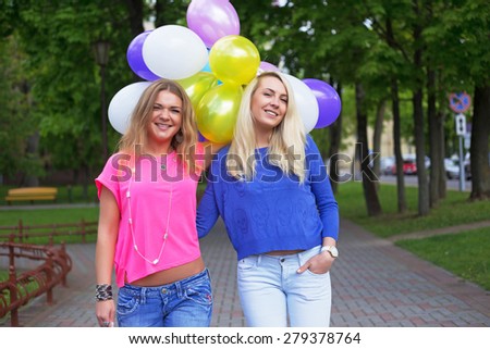Funny crazy emotional pretty fashion girls having fun with balloons in the park