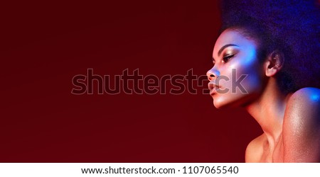 Beautiful dark-haired girl in profile on a claret background. Bright makeup and curvy hair in the style of \
