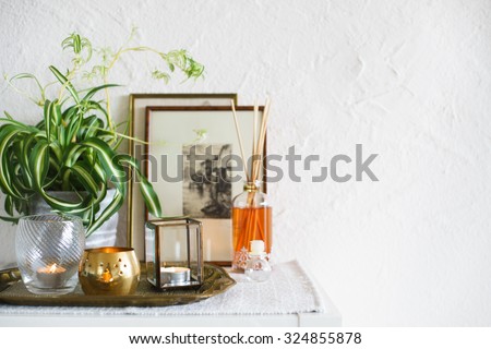 Vintage home decor: candles, aroma diffuser, plant and frames. Selective focus