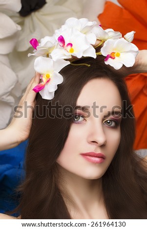 Beautiful girl with a wreath of orchids in her hair