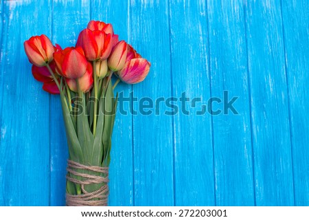 Fresh tulips arranged on old wooden background with copy space for your message