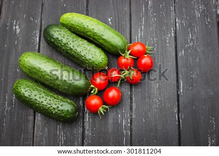 delicious fresh cucumbers and cherry tomatoes lie on a wooden table. Correct and healthy food