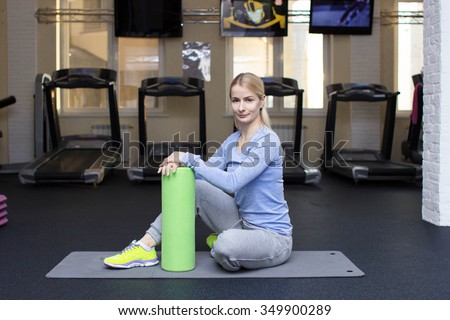 beautiful blond athletic girl in a gym doing exercises. accessories, fitness equipment.