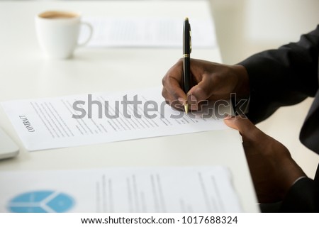 African american businessman agree to make deal signing business contract concept, black man hand putting signature on commercial business paper, filling legal document at work, close up view