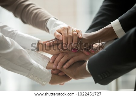 Diverse people putting stacked hands together promising help and support starting common business, black and white multiracial group unite at motivating training, team building concept, close up view