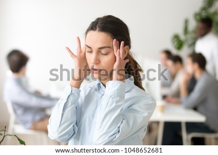 Stressed frustrated young woman employee feeling pain unwell dizzy, tired of difficult office job, suffering from panic attack, hormone imbalance or having headache migraine massaging temples at work