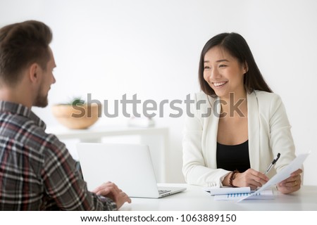 Friendly asian hr smiling laughing talking to candidate at job interview, chinese financial advisor explains customer deal benefit, happy korean businesswoman bank worker consulting client about loan