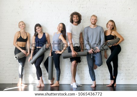 Group portrait of young sporty people looking at camera. Candid students taking rest after fitness activity, time to recover strength, Fitness or yoga instructors friendly smiling, inviting for lesson