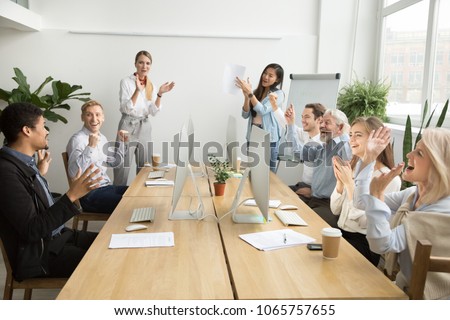Corporate diverse team colleagues congratulating motivated african coworker with business success or achievement clapping hands in coworking office, multiracial employees applaud excited by good news