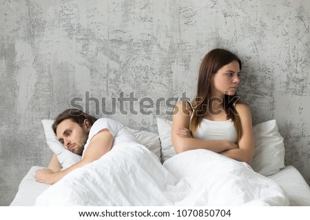 Sad millennial lovers after quarrel fight ignoring avoiding sex in bed, frustrated man and woman not talking feeling offended or stubborn, unhappy married couple and sexual problems concept