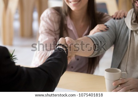 Couple handshaking businessman, smiling customers make successful real estate deal with mortgage broker, lawyer or financial advisor, buying insurance, taking bank loan, close up view of hands shake