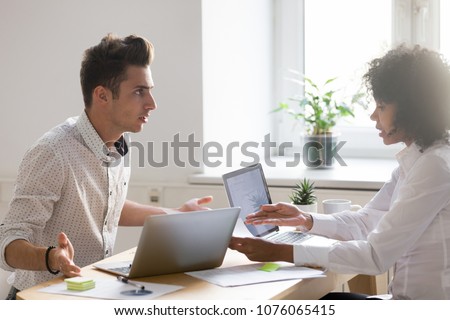Multiracial colleagues argue about document disagree having conflict at work, diverse coworkers disputing about mistake in paperwork, african businesswoman blaming caucasian partner of bad contract
