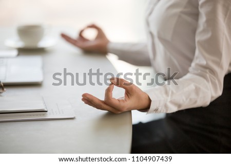 Office meditation for reducing work stress relief concept, female hands in mudra close up view, business woman practicing yoga at workplace for mindfulness development. mental health and balance