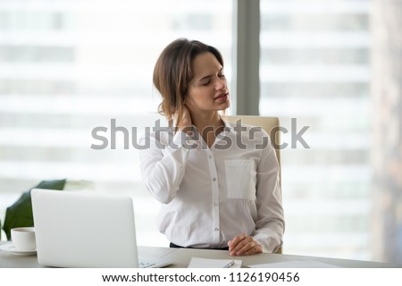 Tired businesswoman feels fatigue massaging tensed muscles of stiff neck trying to relieve pain after sedentary computer work in incorrect posture or uncomfortable office chair, fibromyalgia concept