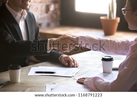 Close up handshake of two successful businesspeople after good deal in the office. Good first impression, making acquaintance concept