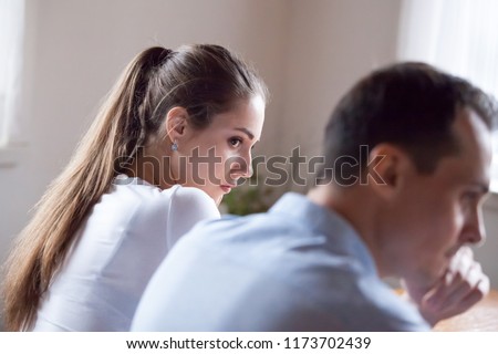 Back view of offended woman looking at stubborn lover refusing reconcile after fight, mad millennial couple not talking after quarrel, man avoid looking or speaking to female after family conflict