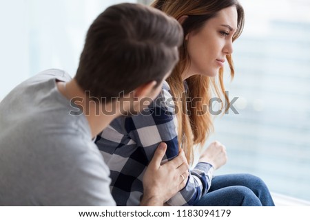 Loving husband comfort upset offended wife, caressing and hugging her from behind, caring man make peace and reconcile with lover, show support, couple in fight overcome family problems together