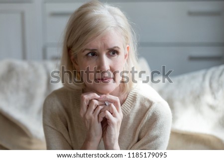 Thoughtful upset mature old lady feeling blue thinking of loneliness or grief, sad middle aged woman worried concerned about problems, serious depressed senior female widow crying grieving mourning