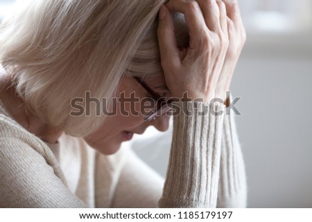Stressed sad tired middle aged senior woman holding head in hands feeling headache migraine concept, upset old elderly mature lady in panic suffering from pain, alzheimer disease, anxiety depression