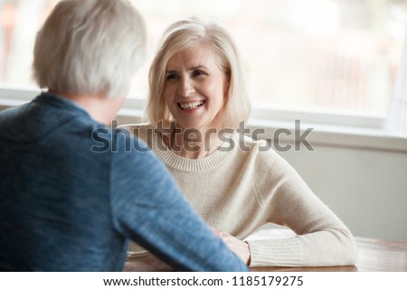 Smiling beautiful mature woman listening to elderly man talking, senior happy retired family enjoying pleasant conversation, senior couple dating concept, good relations love in older people marriage