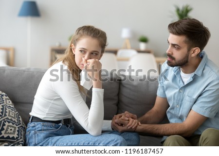 Unhappy married couple. Girl crying guy calms her. Guilty Husband after quarrel apologize, interruption of unwanted pregnancy or miscarriage. Friend support girlfriend after break up with a loved one