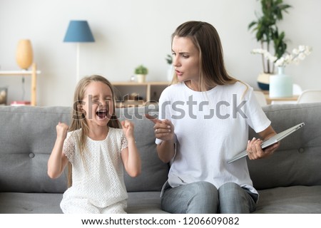 Stubborn little girl scream loud not listening to strict mom, serious young mother scold shouting daughter for bad behavior, working mommy lecture kid yelling asking attention. Family conflict concept