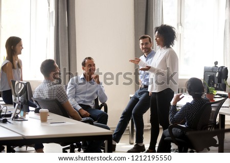 Smiling african manager coach speaking at diverse corporate group meeting, female black teacher team leader talking to office workers at training teaching employees explaining new idea, mentoring