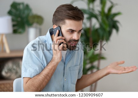 Angry man talk on smartphone arguing or solving problem, irritated male have cell phone conversation manage work trouble, annoyed guy use mobile call customer service disputing or complaining