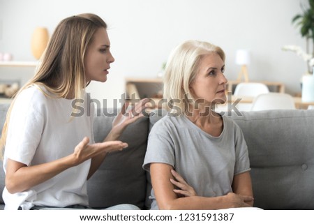 Annoyed adult daughter arguing with stubborn old senior mother in law ignoring not listening to young woman talking explaining problem, different generations disagreements family conflicts concept