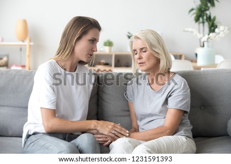 Loving adult daughter talking to sad old mother holding hand comforting upset older woman having problem, young caregiver helping senior patient, support, empathy and care to elderly parent concept