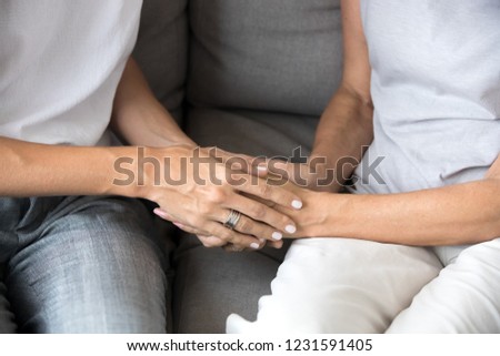 Close up view of young woman daughter holding old mother female hands as concept of different older and younger generations support, giving love and care to senior people, helping elderly parents