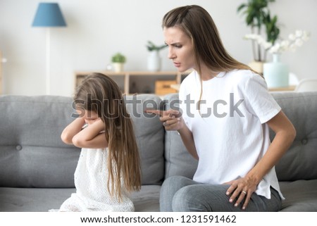 Angry mother scolding lecturing stubborn kid closing ears not listening to mom, strict mum talking to rebellious child demanding discipline from preschool girl ignoring rebuke family conflict concept