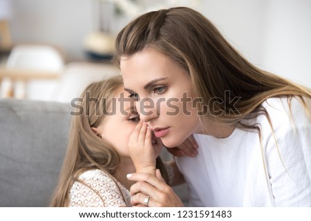 Loving mother listens to child girl whispering in ear telling psychological problem, serious caring mom supporting little daughter share secret, honesty trust understanding in parent and kid relation