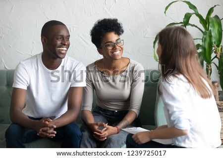 Happy African American couple at successful visit psychologist, smiling wife and husband sitting together on couch after good family therapy session, satisfied clients, help spouses solve problem