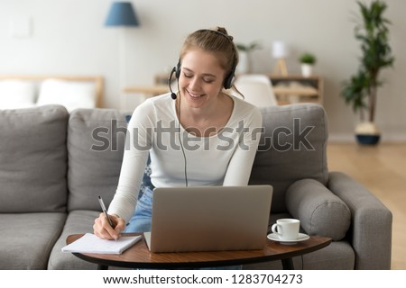 Happy girl interpreter in headset translate write notes listen audio course study work on laptop, smiling teen student wearing headphones learning online training class, distance education concept