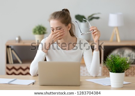 Tired young woman student feeling eye strain bad blurry vision rubbing dry irritated eyes taking off glasses after computer work, fatigued teen girl suffer from discomfort tension problem concept