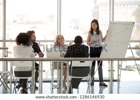 Multiracial company team diverse staff gathered at boardroom together for brainstorming negotiating. Business people listen skilled coach. Business plan startup, effective marketing strategy concept