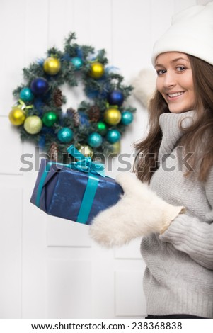 Girl with a gift knocking on the door