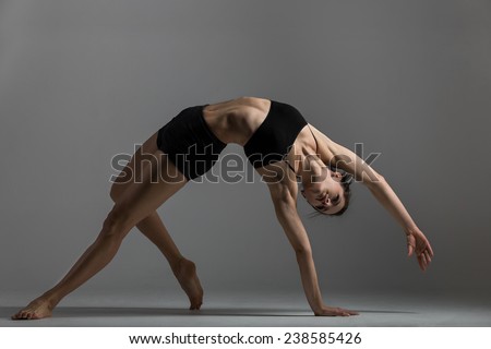 Gymnast girl is training performing exercise bridge, asana Camatkarasana, Wild Thing,  Dancing Dog yoga pose