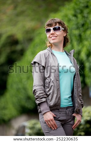 Happy smiling girl out on the walk in park in casual clothes