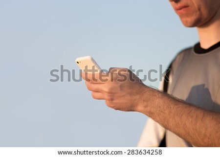 Young Caucasian man hands holding cellphone, using app, making call, messaging text or dialing number, close up, copy space