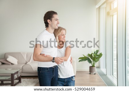 Young happy couple, holding a key, purchased a new apartment, rather than throw money away on rent, flat as the biggest investment, planning a future, preparing a housewarming party
